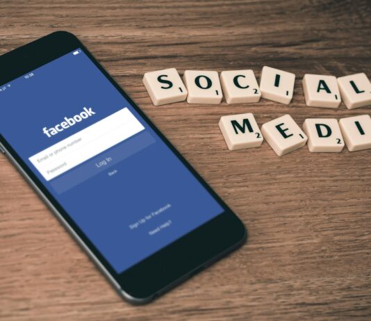 디지털 디톡스, 마음의 건강을 지키는 새로운 습관 space gray iPhone 6 with Facebook log-in display near Social Media scrabble tiles