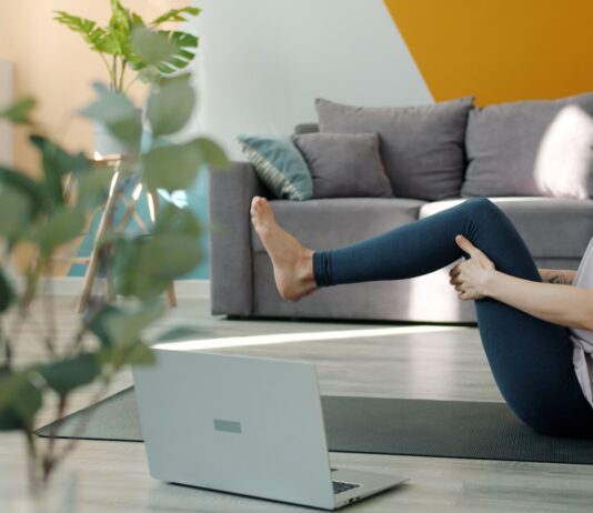 MZ세대부터 시니어까지…필라테스, 전 연령층 사로잡은 웰니스 운동 트렌드 Woman doing yoga in front of a laptop
