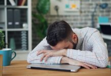 “늘 피곤한 당신, 만성피로 극복하는 ‘슬로우 라이프’ 바람” a man sitting at a desk with his head in his hands