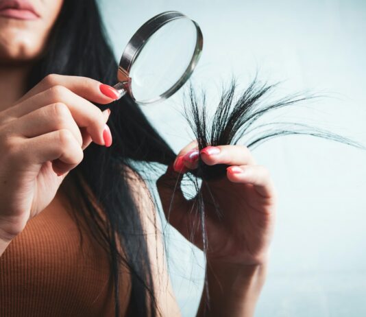 건강한 두피와 아름다운 머릿결, 생활 속 머리카락 관리법이 주목받는다 Woman examining split ends of hair with magnifying glass