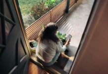 만성피로의 그늘, 일상 속 실천으로 밝게 걷자 Woman sitting on balcony with smartphone
