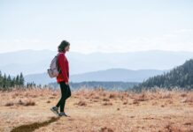 걷기 운동, 일상 속에서 자연스럽게 실천하는 건강 습관 a man with a backpack walking across a dry grass covered field