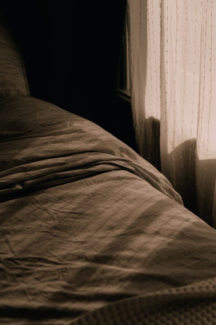 A bed sitting next to a window in a bedroom